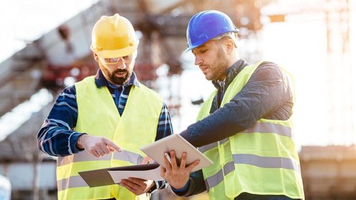 Engineer And A Construction Site Manager Examining A Blueprint Stock Photo